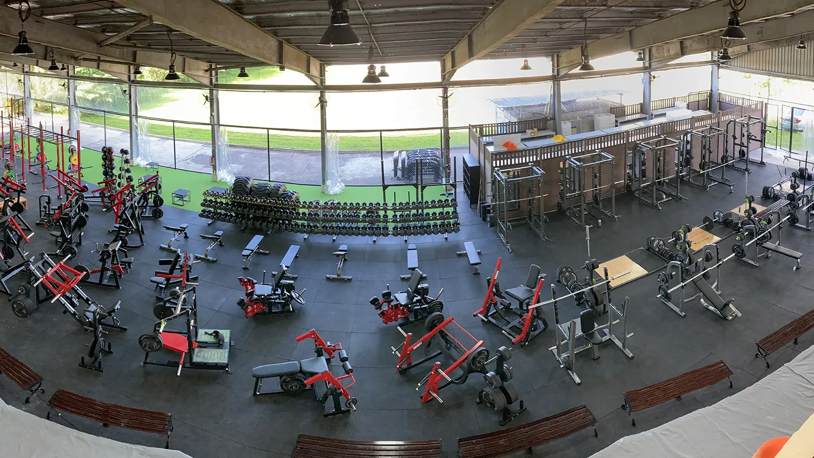 An overhead view of a Singapore strength-training floor with racks, benches, dumbbells and machines